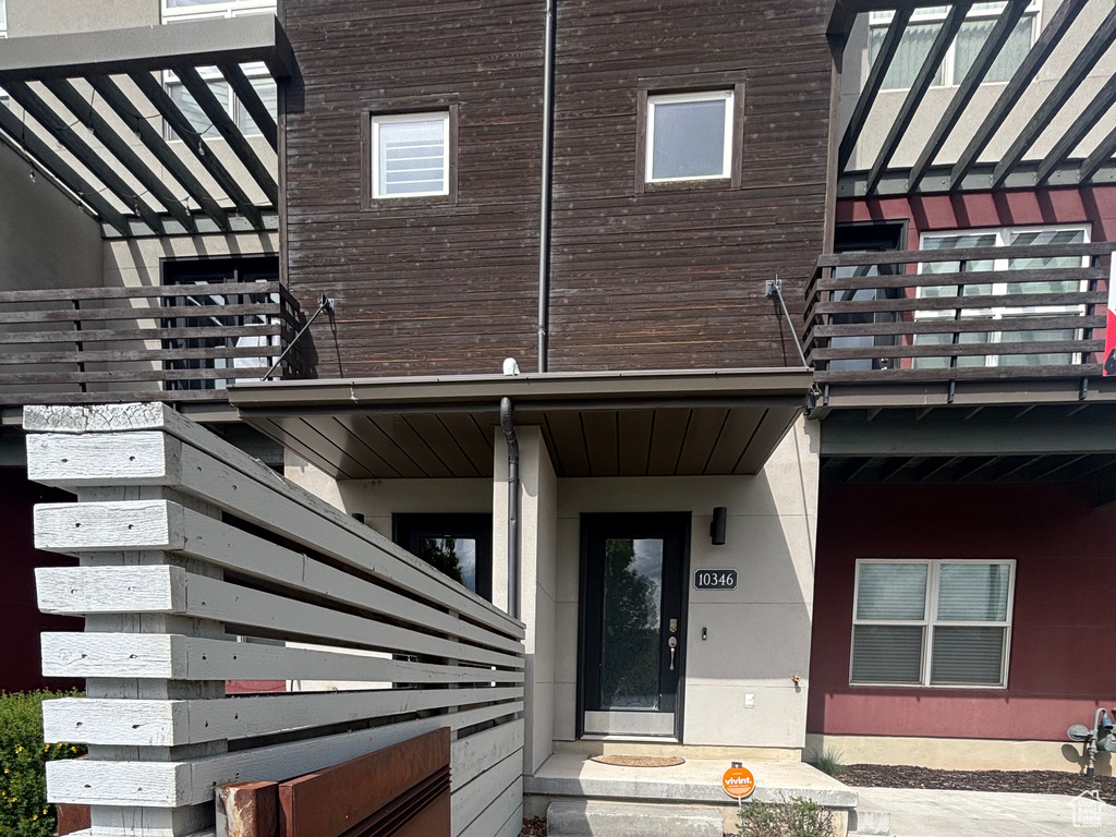 View of exterior entry with a balcony