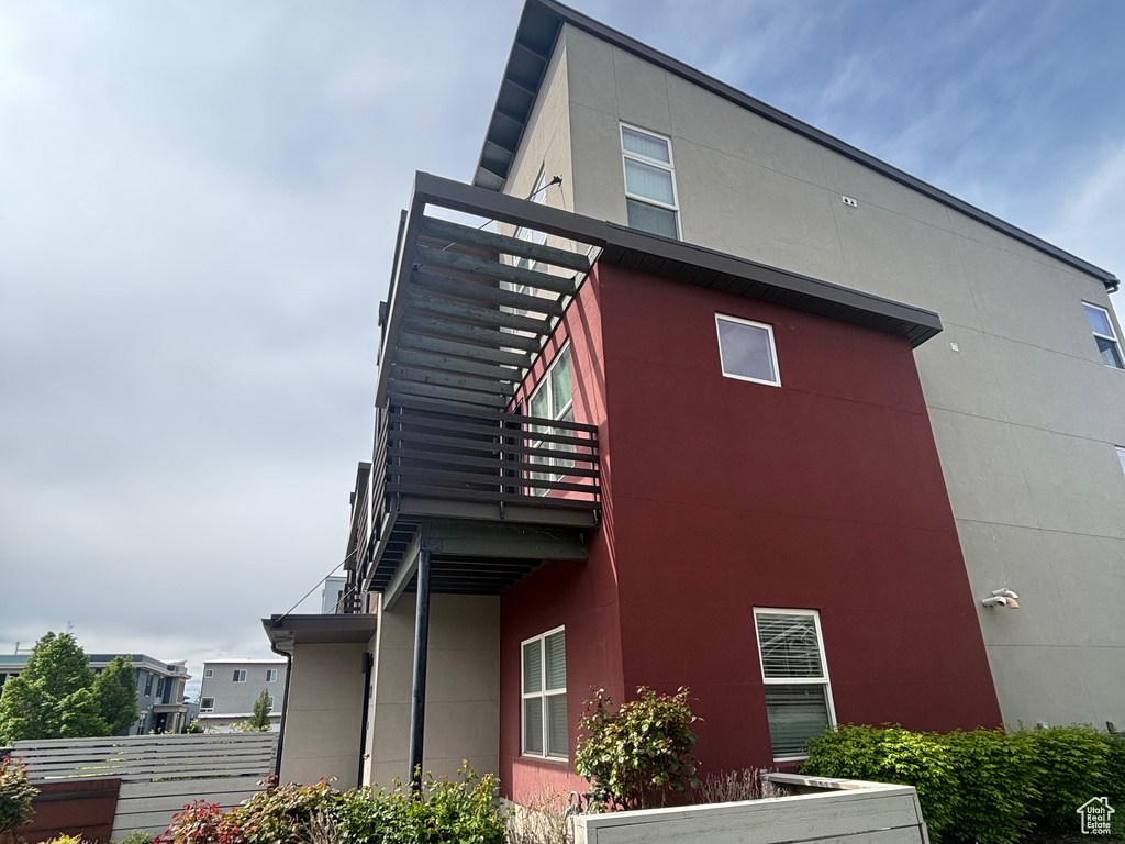 View of home\'s exterior with stucco siding and a balcony