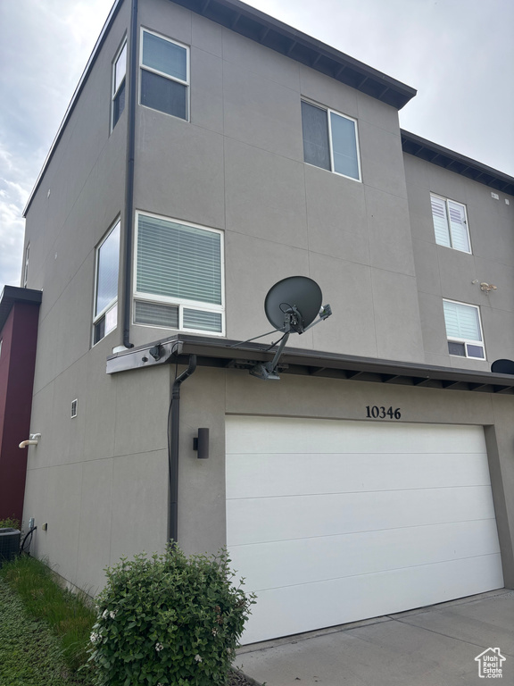 View of property exterior with stucco siding and a garage