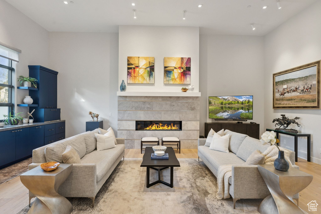 Living area featuring light wood finished floors, a tile fireplace, and recessed lighting