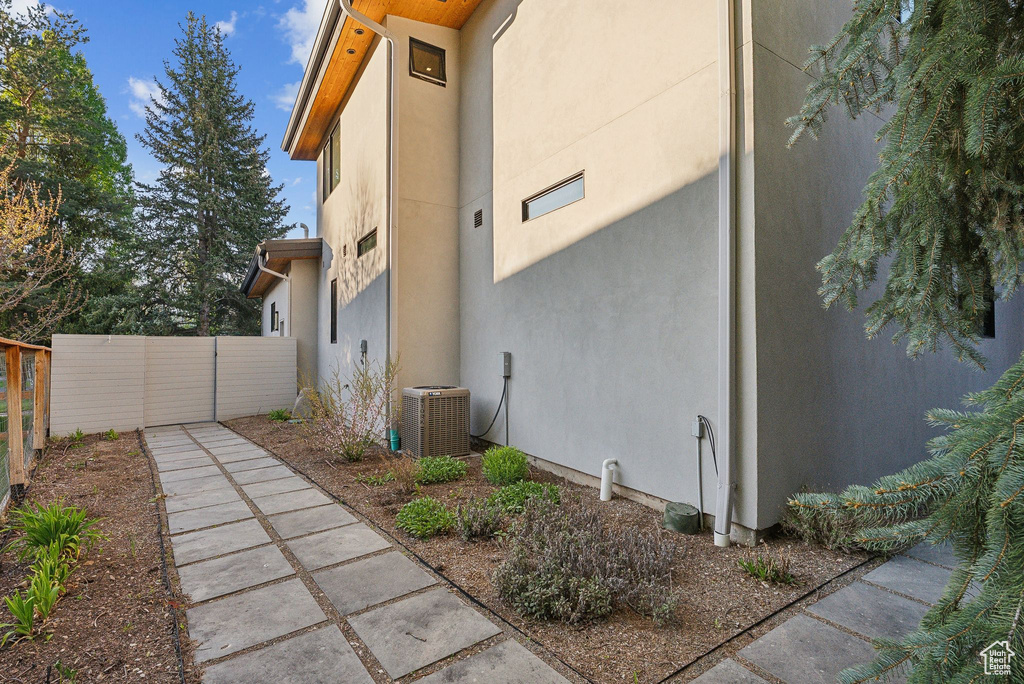 View of side of home with stucco siding and cooling unit