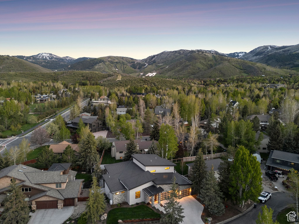 Aerial view of property and surrounding area featuring a mountain backdrop and nearby suburban area