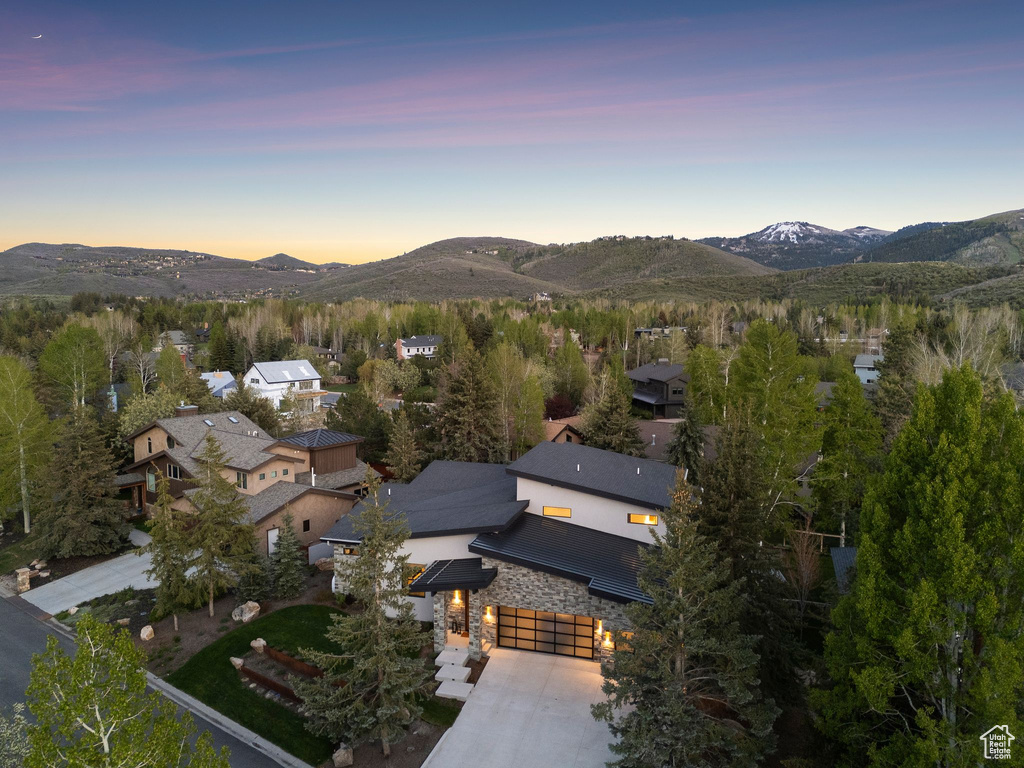 Aerial view of property and surrounding area with mountains and nearby suburban area
