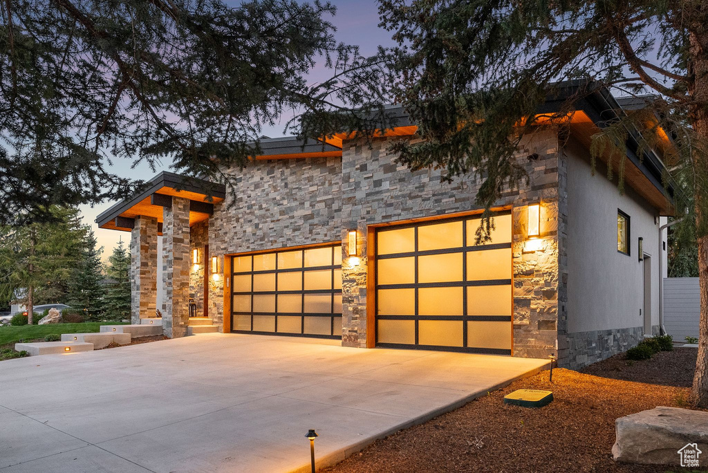 View of front facade featuring stone siding and concrete driveway
