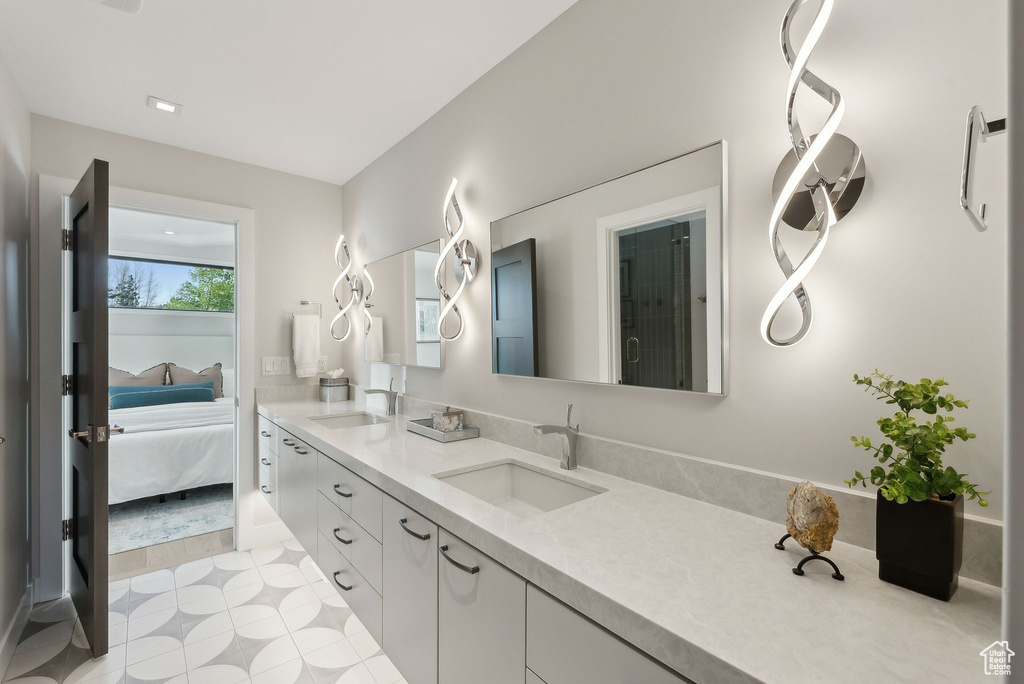 Ensuite bathroom with double vanity and tile patterned flooring