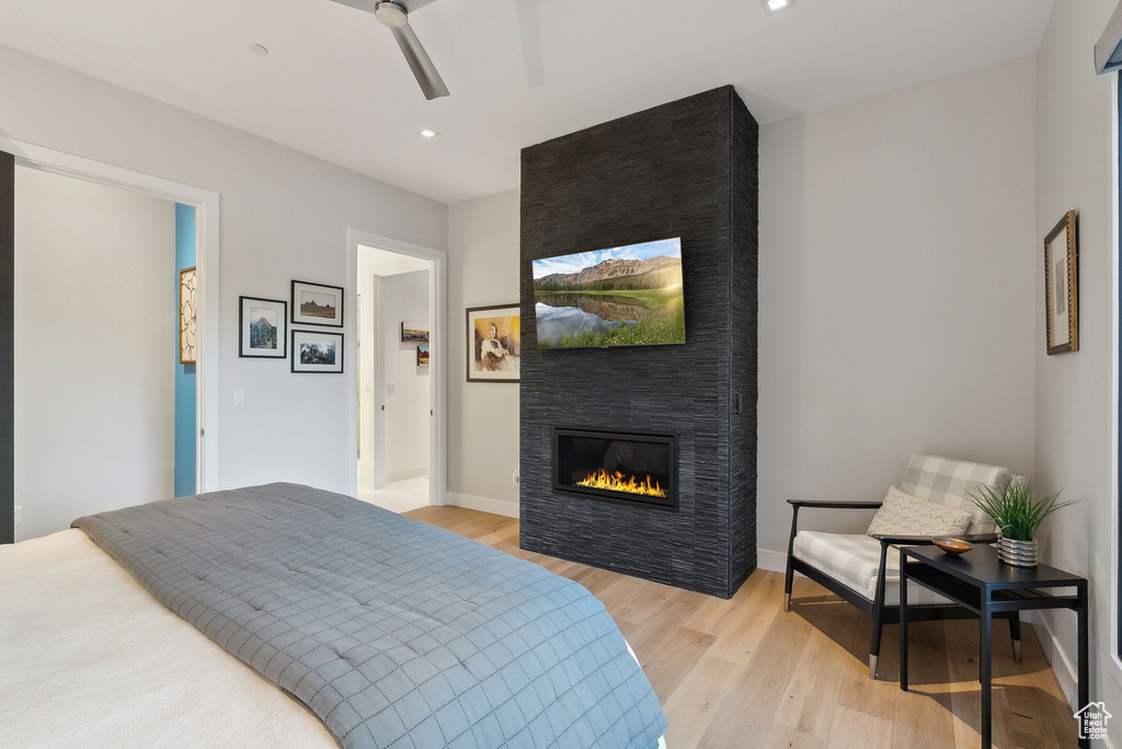 Bedroom with light wood-type flooring, a fireplace, baseboards, ceiling fan, and recessed lighting