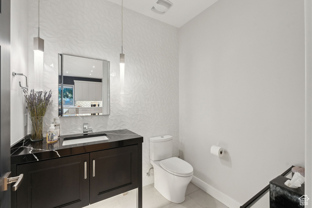 Bathroom featuring toilet, tile patterned flooring, and vanity