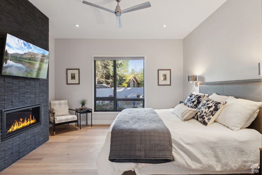 Bedroom with light wood-style flooring, a fireplace, recessed lighting, and a ceiling fan