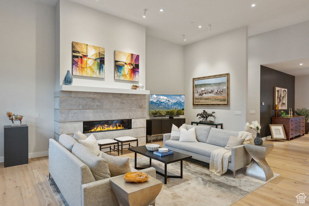 Living area featuring light wood-style floors, recessed lighting, a fireplace, and baseboards