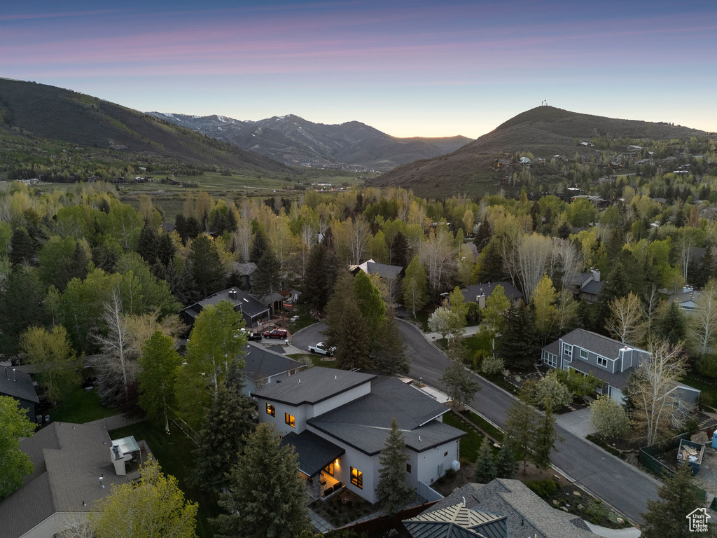 Aerial view of property and surrounding area featuring a mountain backdrop