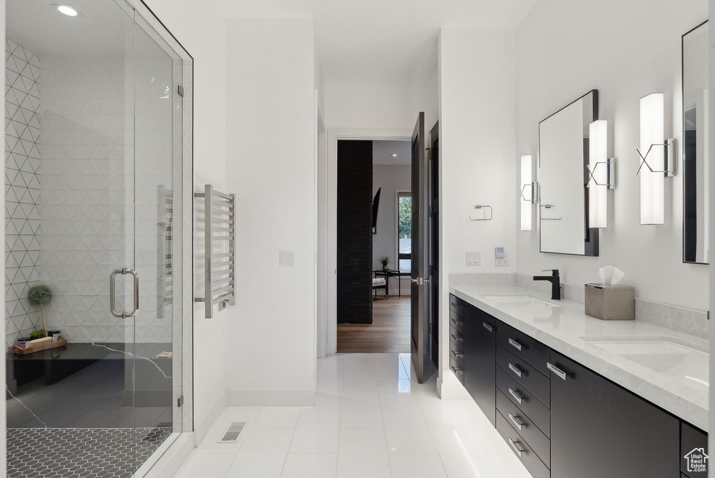 Full bathroom featuring tile patterned flooring, a shower stall, double vanity, recessed lighting, and baseboards
