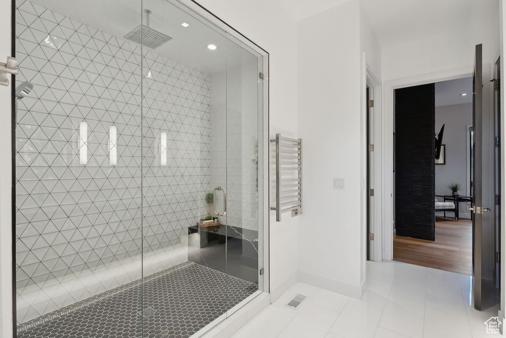 Full bathroom featuring tile patterned floors, a shower stall, a towel warmer, recessed lighting, and baseboards
