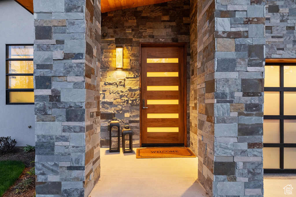 Entrance to property featuring stone siding