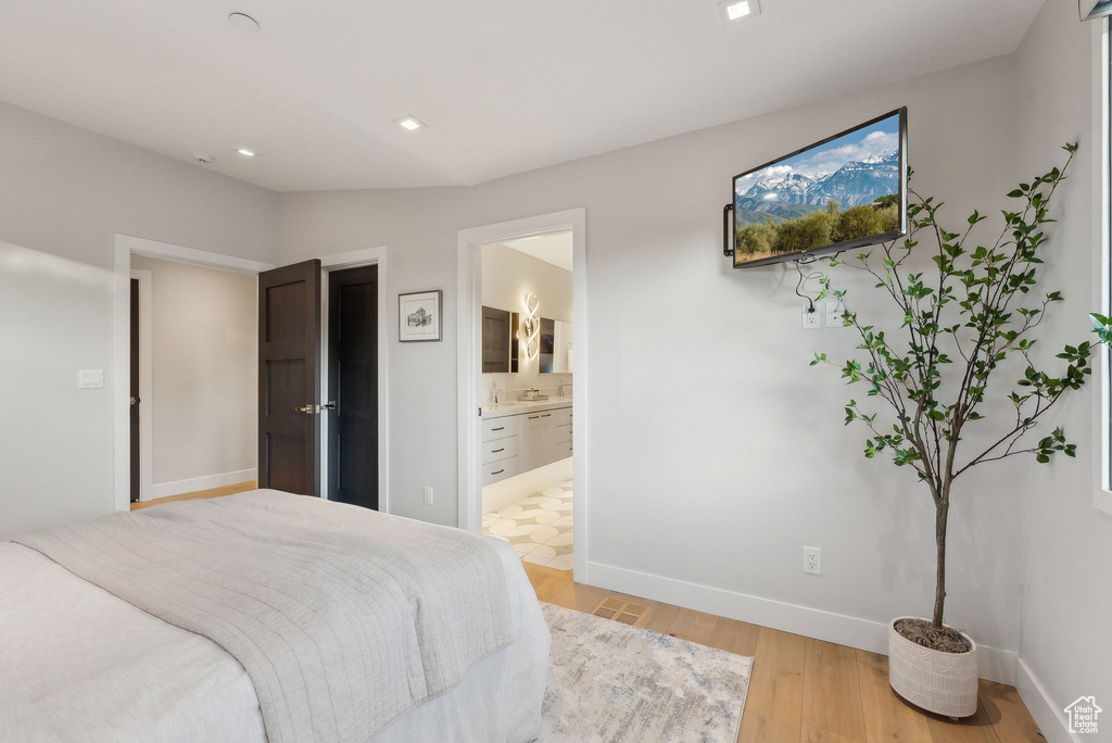 Bedroom featuring light wood-type flooring, ensuite bath, baseboards, and recessed lighting