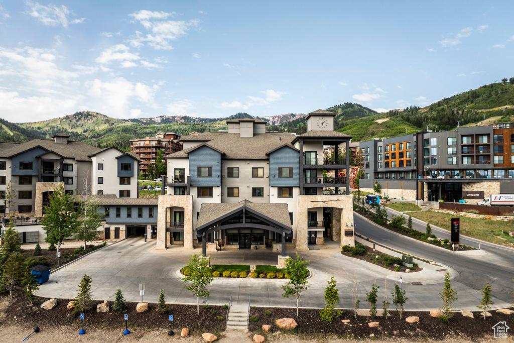 Rear view of property with a mountain view and a balcony