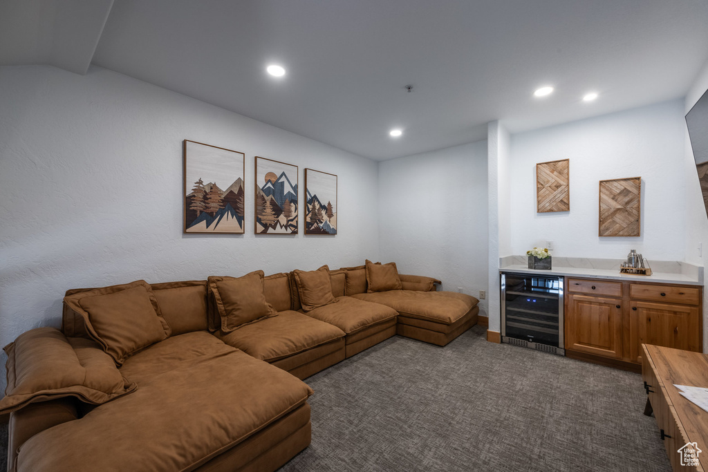 Living room with beverage cooler, a dry bar, dark colored carpet, and recessed lighting