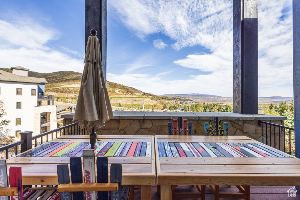 Wooden terrace featuring a mountain view and outdoor dining space