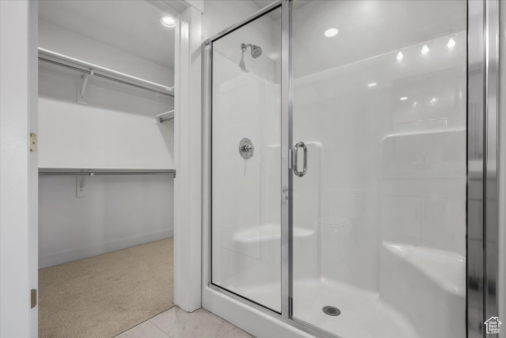 Full bath featuring a spacious closet and a shower stall