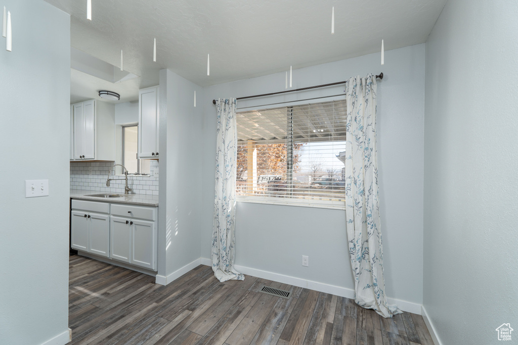 Unfurnished dining area with dark hardwood / wood-style flooring and sink