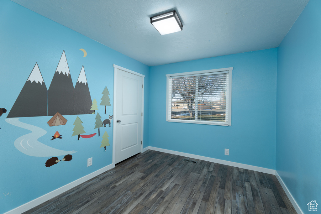 Unfurnished room featuring dark hardwood / wood-style floors