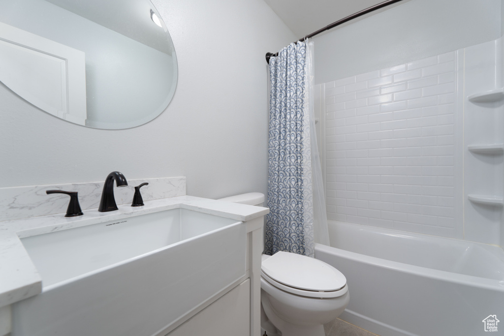 Full bathroom with vanity, toilet, and shower / bath combo with shower curtain