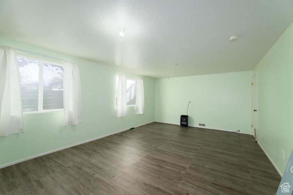 Empty room with dark wood-type flooring