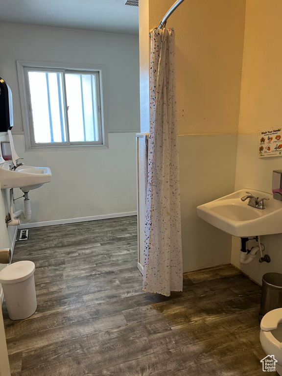 Bathroom with a shower with shower curtain, toilet, wood-type flooring, and sink