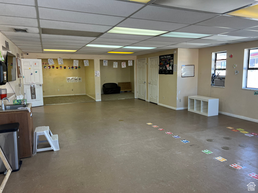 Basement with a paneled ceiling and sink
