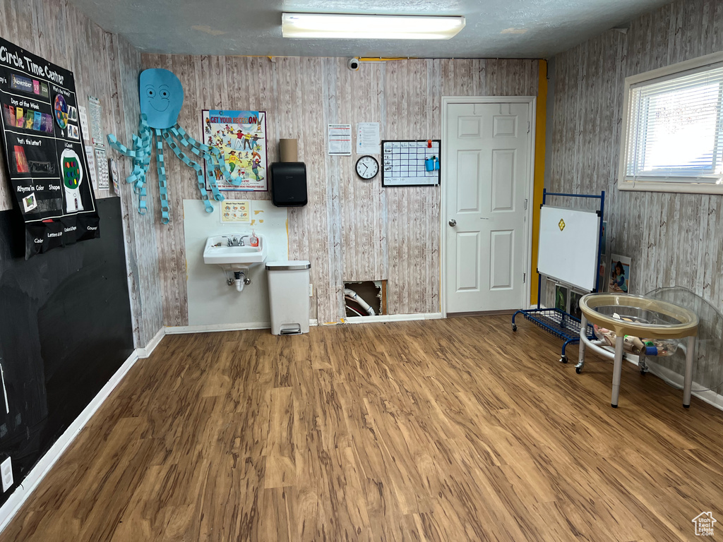 Miscellaneous room featuring wooden walls, hardwood / wood-style floors, and sink