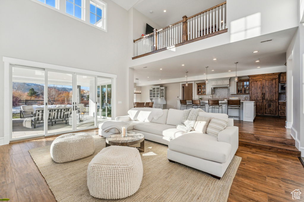 Living room featuring a towering ceiling and dark wood-type flooring