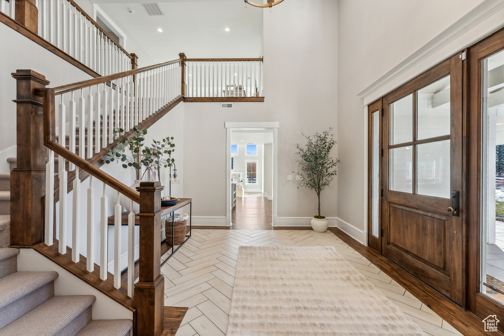 Entryway with plenty of natural light, light parquet flooring, and a high ceiling