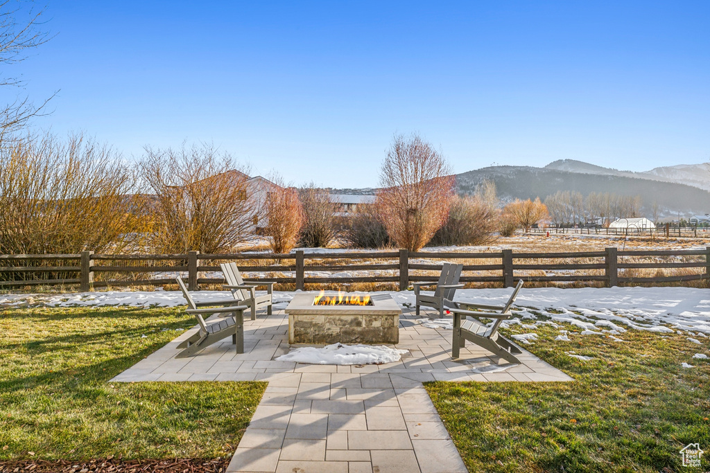 View of yard featuring a mountain view, a patio, and an outdoor fire pit