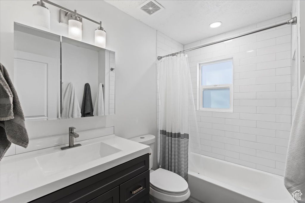 Full bathroom with vanity, toilet, and shower / tub combo