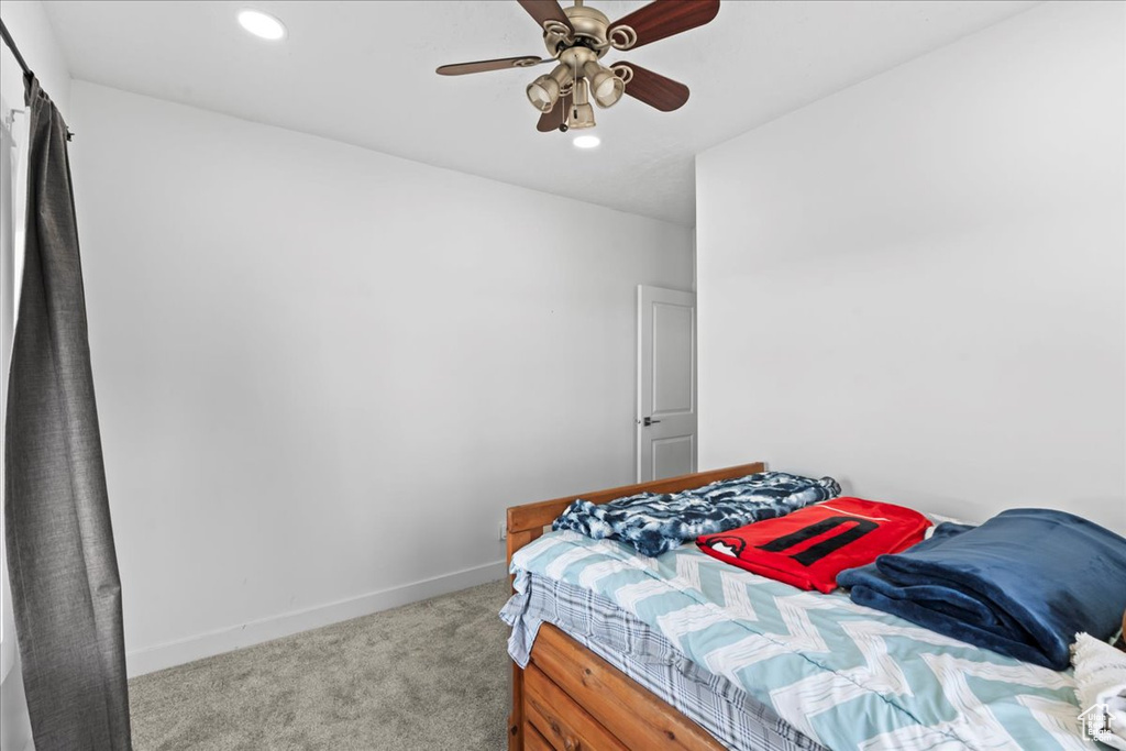 Bedroom with ceiling fan and light colored carpet