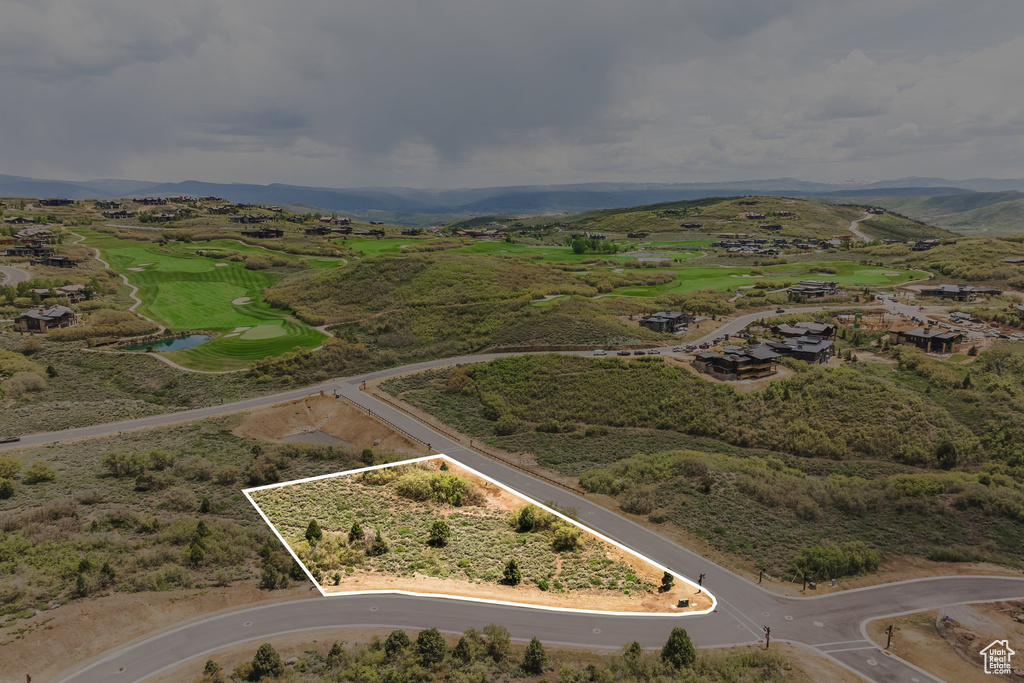 Aerial overview of property's location with property parcel outlined and a mountainous background