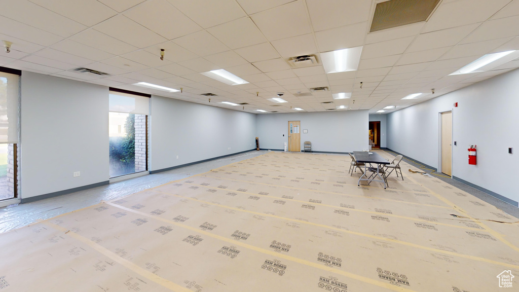 Empty room featuring a paneled ceiling and a healthy amount of sunlight