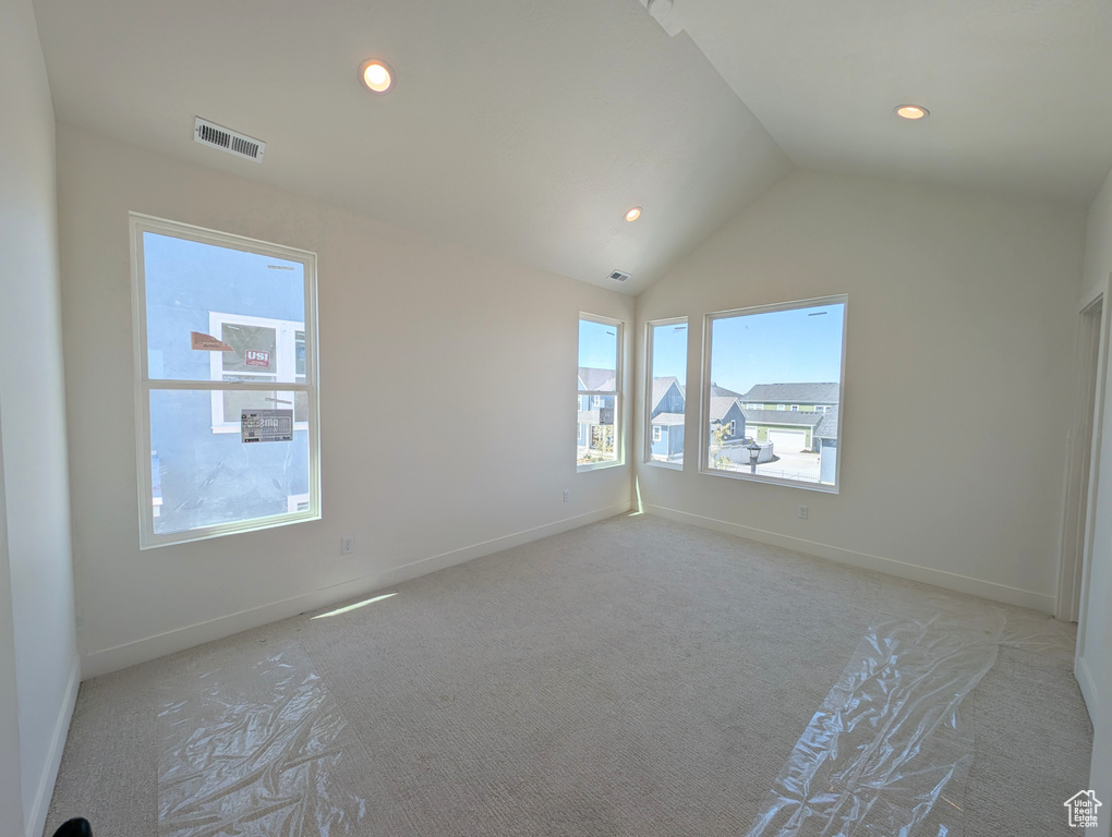 Unfurnished room with visible vents, light carpet, baseboards, recessed lighting, and vaulted ceiling