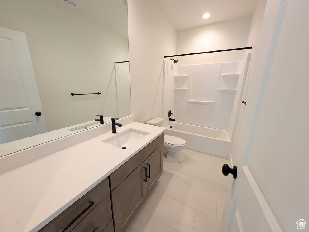 Bathroom with visible vents, shower / tub combination, vanity, tile patterned floors, and toilet