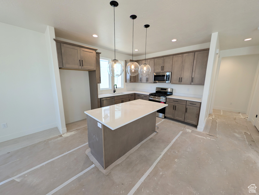 Kitchen with a center island, recessed lighting, a sink, hanging light fixtures, and stainless steel appliances