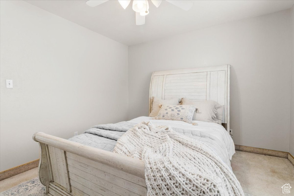 Bedroom featuring light carpet, baseboards, and ceiling fan