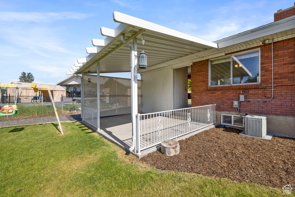 Property entrance featuring central air condition unit and a lawn