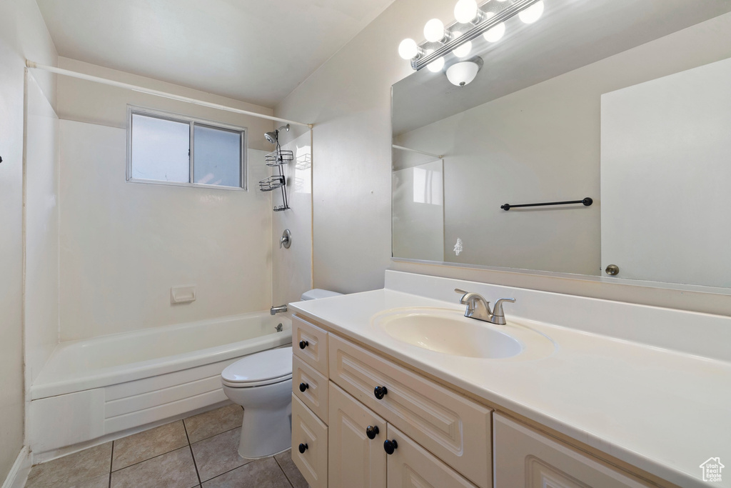 Full bathroom with vanity, tile patterned floors, tiled shower / bath combo, and toilet