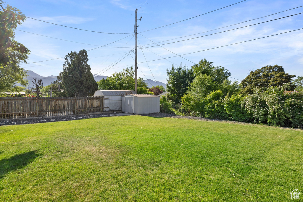 View of yard with a mountain view and a shed