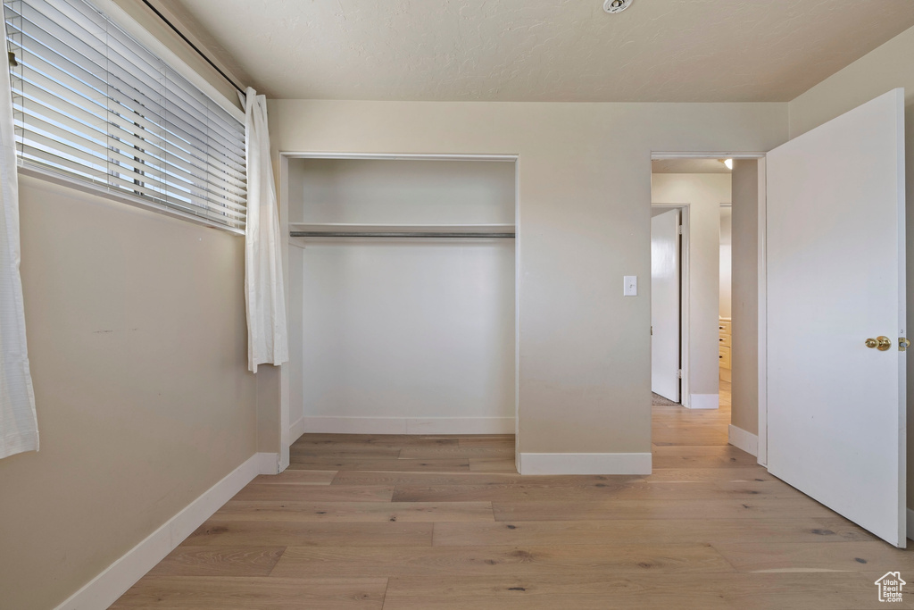 Unfurnished bedroom featuring a closet and light hardwood / wood-style floors