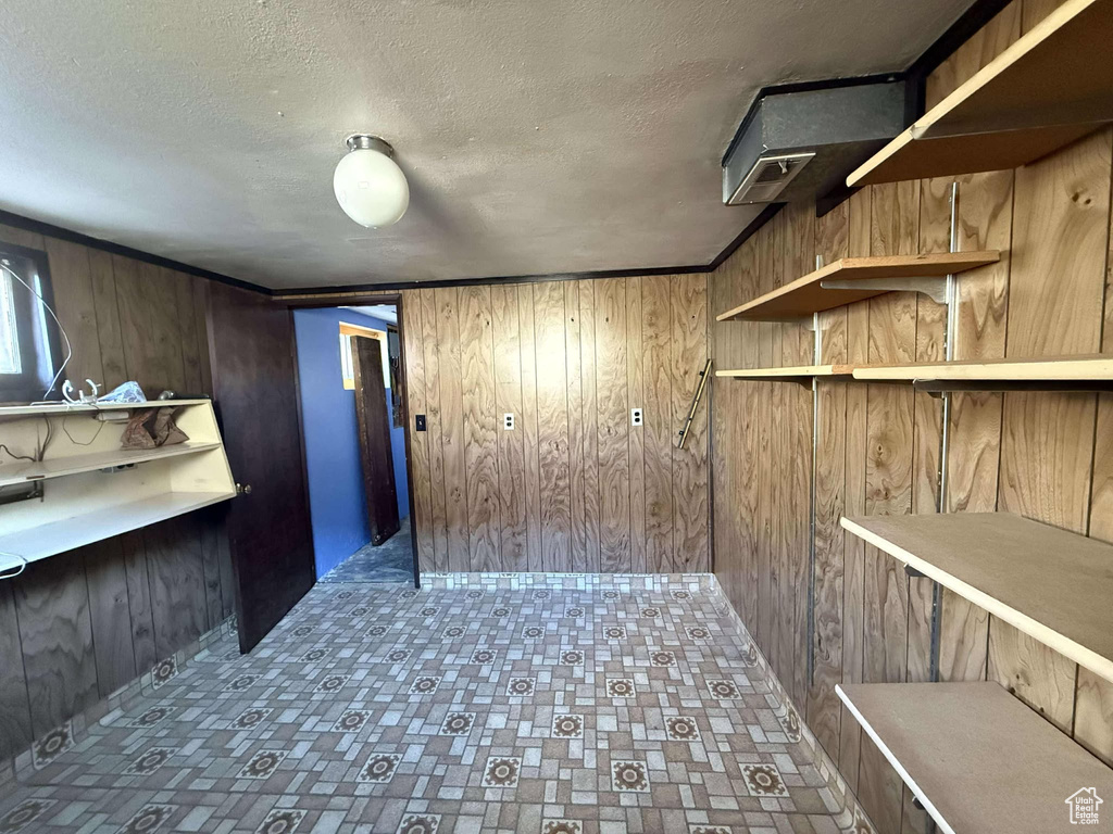 Interior space featuring a textured ceiling and wood walls