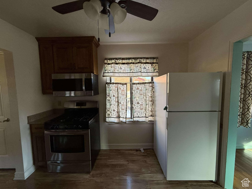 Kitchen featuring appliances with stainless steel finishes, ceiling fan, and dark wood-type flooring