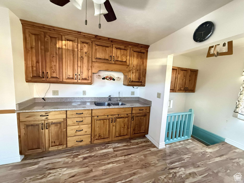 Kitchen featuring dark hardwood / wood-style floors, ceiling fan, and sink