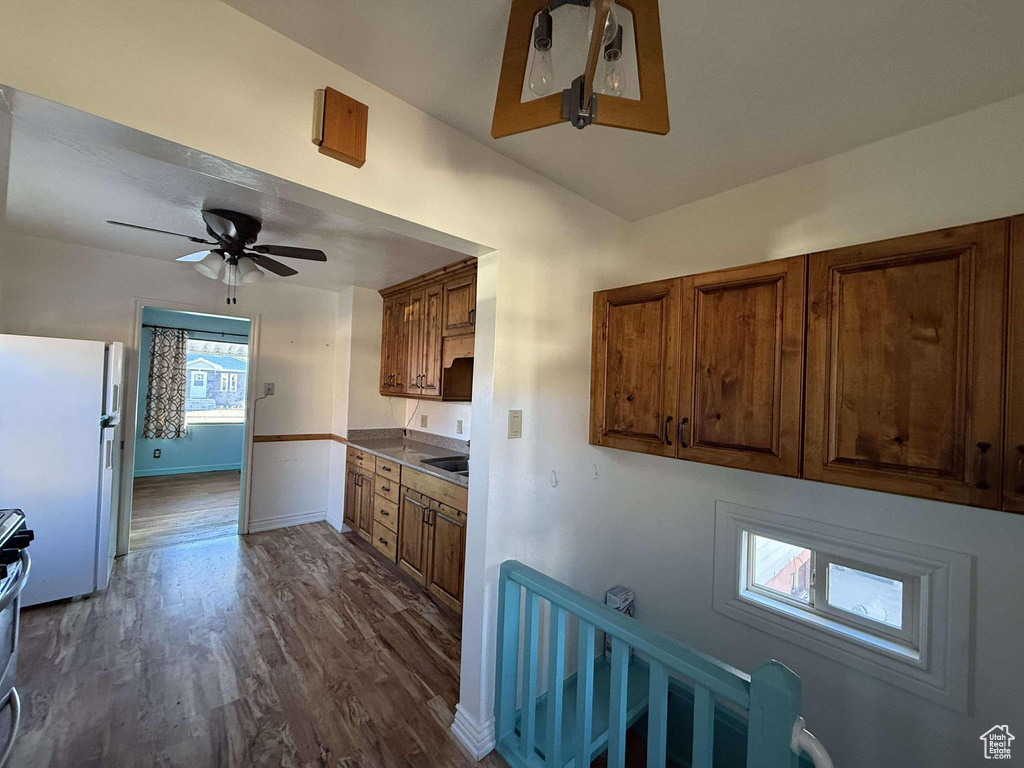 Kitchen featuring ceiling fan, sink, stainless steel range oven, dark hardwood / wood-style floors, and white refrigerator