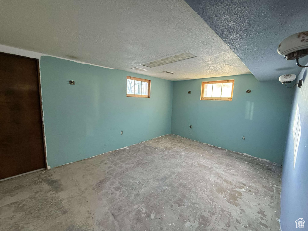 Basement featuring a textured ceiling