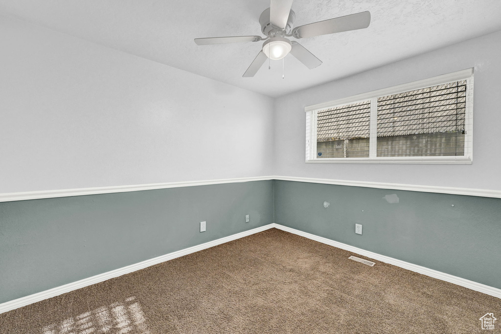 Carpeted spare room with ceiling fan